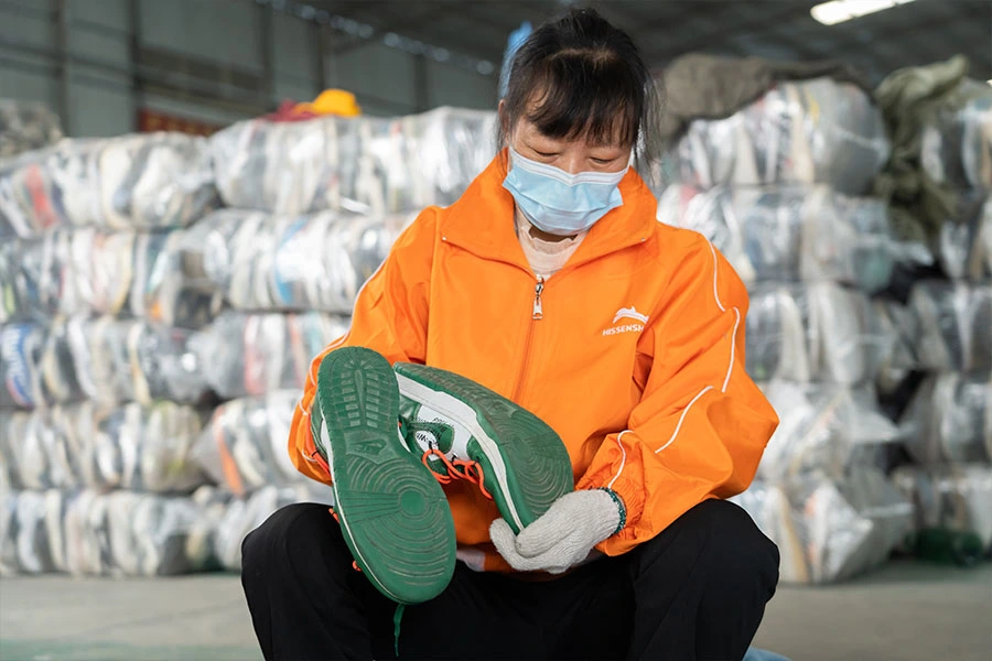 Employee examining the quality and condition of shoes